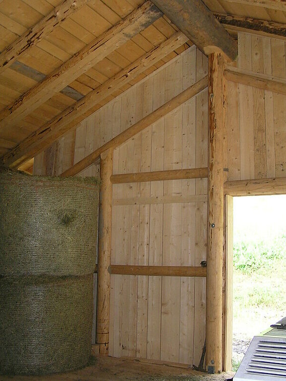 Landwirtschaftliche Halle mit Naturstämmen